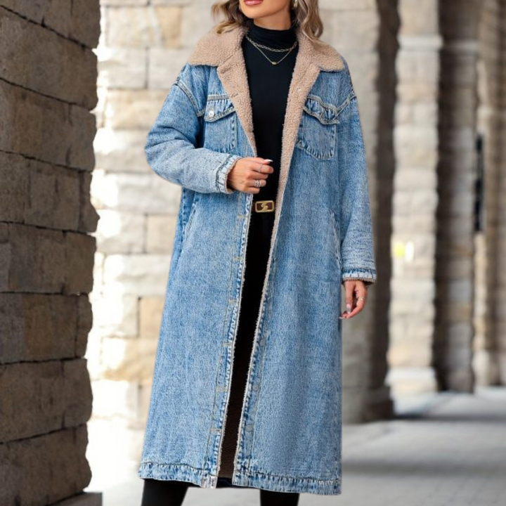 Vrouw in lange blauwe spijkerjas met schapenvachtkraag, zwarte jurk en laarzen. Modieuze winteroutfit, stedelijke achtergrond, casual stijl.