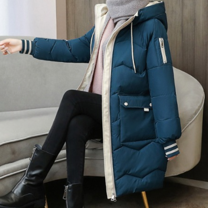 Blauwe gewatteerde winterjas met capuchon, ritssluiting en gestreepte manchetten, gedragen door zittende persoon. Stijlvolle damesmode, warme kleding.