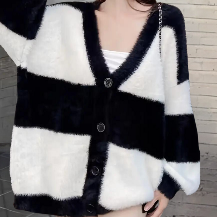 Dames gebreid vest met zwart-wit blokpatroon, V-hals en knoopsluiting. Modieuze, warme kleding voor herfst en winter.