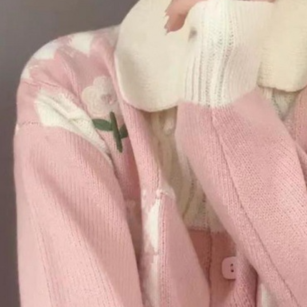 Roze gebreid vest met witte bloemenprint en knopen, zachte stof, lange mouwen, ideaal voor damesmode en herfstkleding.
