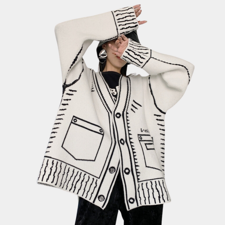 Witte oversized cardigan met zwarte stiksels en zakken, gedragen door model. Trendy damesmode, comfortabele gebreide kleding, herfst-winter stijl.