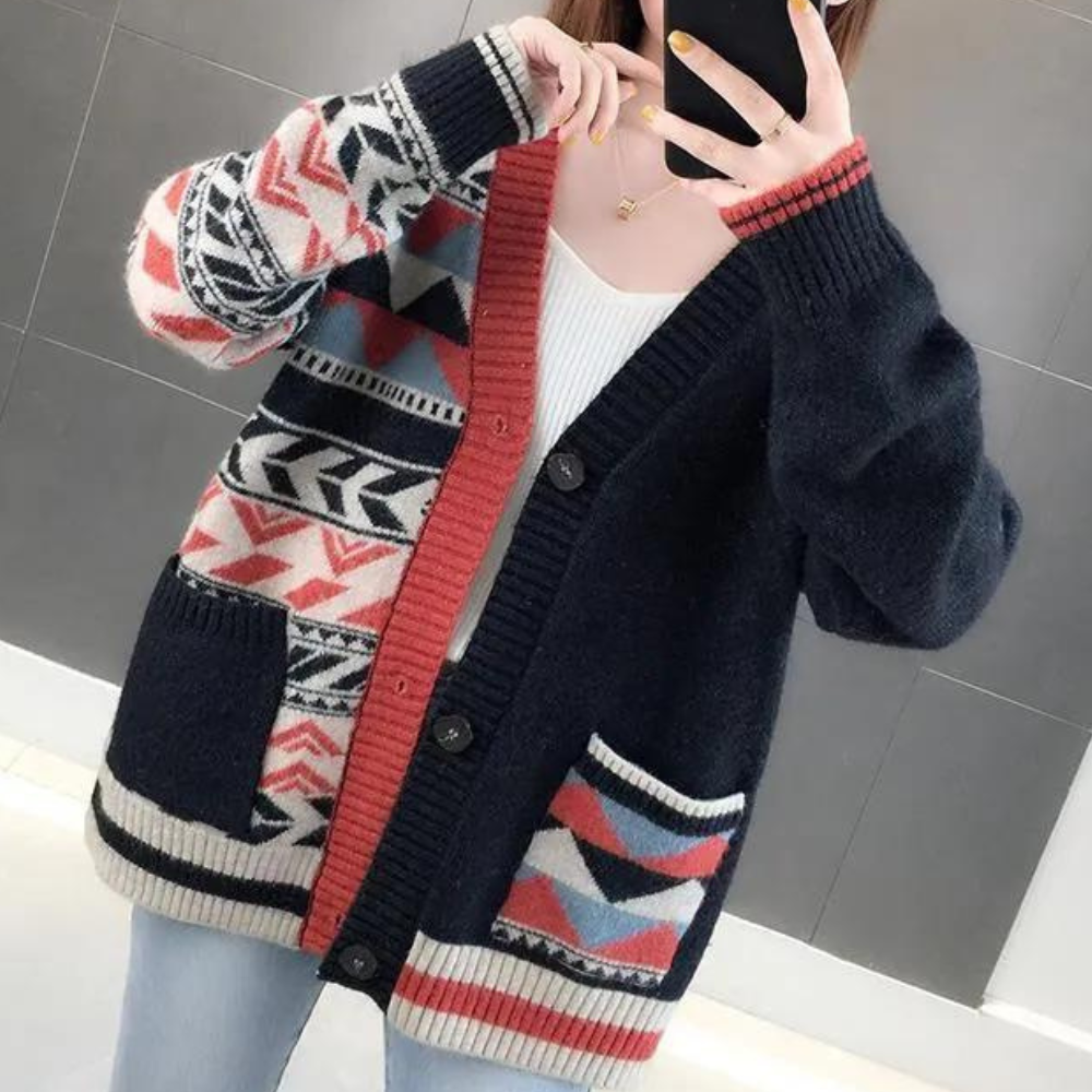 Vrouw draagt zwarte gebreide cardigan met kleurrijk Azteeks patroon, knopen en zakken. Modieuze dameskleding, herfst-winter stijl.