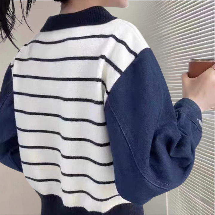Vrouw in gestreepte trui met donkerblauwe mouwen, houdt een kopje vast. Modieuze dameskleding, casual stijl, comfortabele outfit.