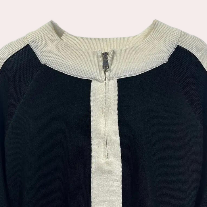 Zwart-witte trui met ritssluiting, raglanmouwen en contrasterende verticale streep. Moderne damesmode, comfortabele en stijlvolle kleding.