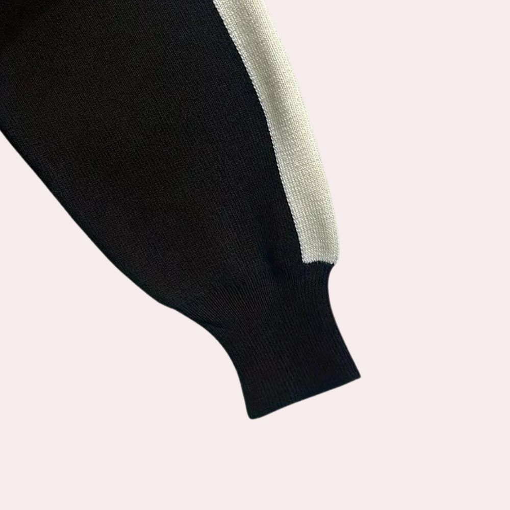 Zwarte trui met witte streep, gebreide mouw, minimalistisch design, hoogwaardige stof, modieuze kleding, comfortabele pasvorm, trendy stijl.