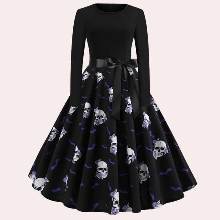 Zwarte vintage jurk met lange mouwen, schedelprint en paarse vleermuizen. Perfect voor Halloween of gothic stijl. Elegante strik in de taille.