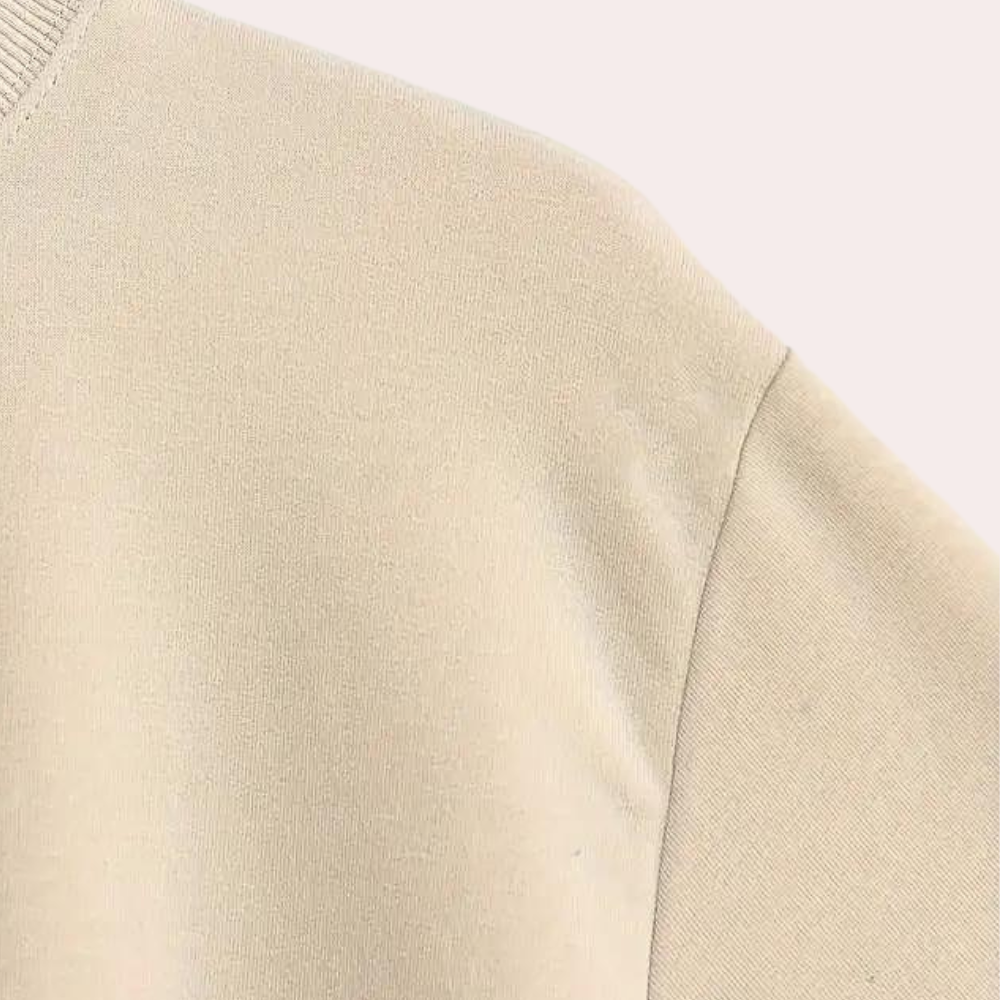 Beige katoenen trui, close-up van de stof en naad, minimalistisch ontwerp, comfortabele casual kleding, modetrend, uniseks, duurzaam materiaal.