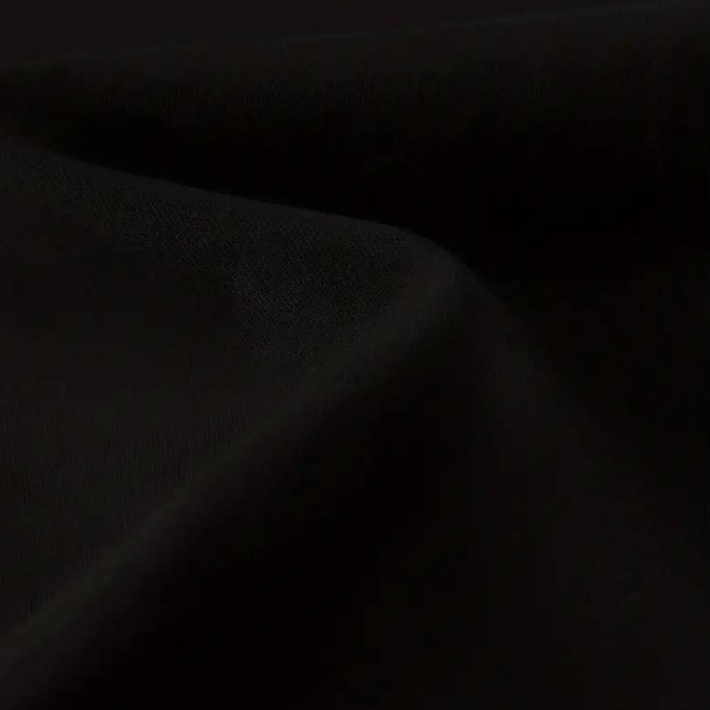 Zwarte katoenen stof close-up, gladde textuur, geschikt voor kleding en interieur, hoogwaardige kwaliteit, perfect voor naai- en modeprojecten.