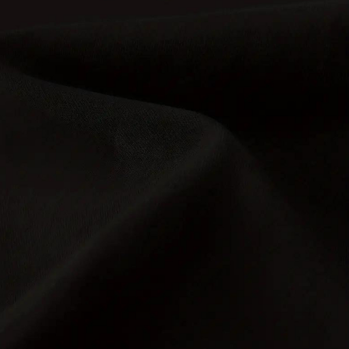 Zwarte katoenen stof close-up, gladde textuur, geschikt voor kleding en interieur, hoogwaardige kwaliteit, perfect voor naai- en modeprojecten.