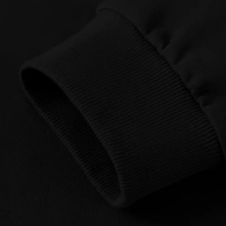 Zwarte sweatshirt mouw met geribbelde manchetten, close-up detail. Hoogwaardige katoenen stof, casual kleding, unisex mode.