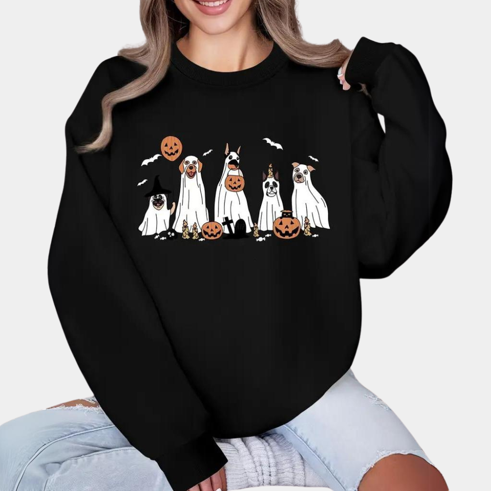 Vrouw draagt zwarte Halloween-trui met cartoonhonden verkleed als spoken, pompoenen en vleermuizen. Perfect voor Halloween mode en feestkleding.