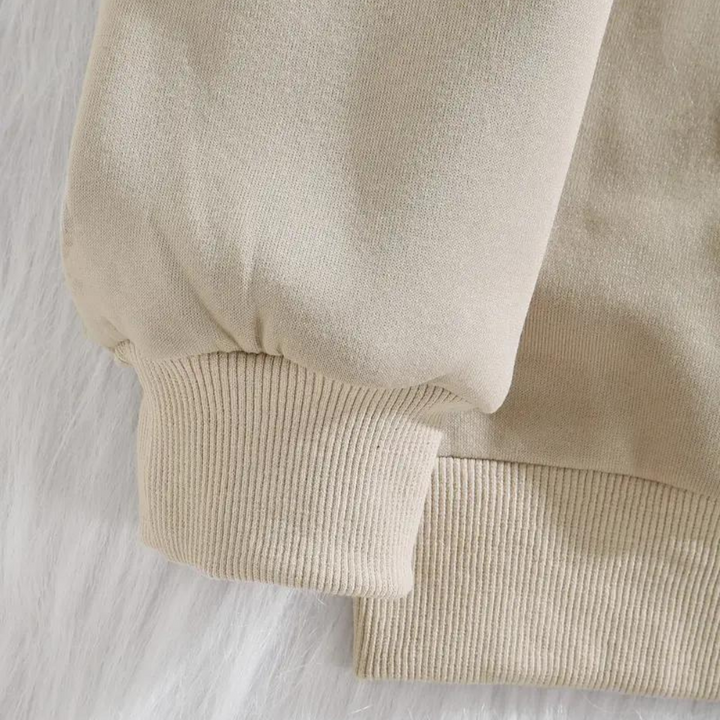 Beige sweater met geribbelde manchetten en zoom, close-up. Comfortabele, casual kleding, ideaal voor herfst- en wintermode. Zachte stof.