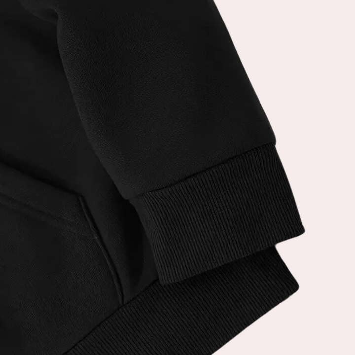 Zwarte katoenen trui met geribde manchetten en zakdetail, close-up. Comfortabele en stijlvolle kleding voor dagelijks gebruik.