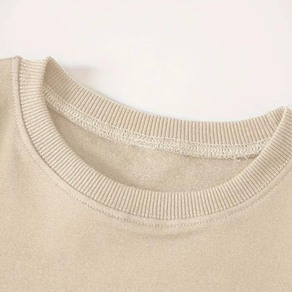Beige sweater met ronde hals, close-up van de kraag. Hoogwaardige stof, casual stijl, unisex trui. Perfect voor herfst- en wintermode.
