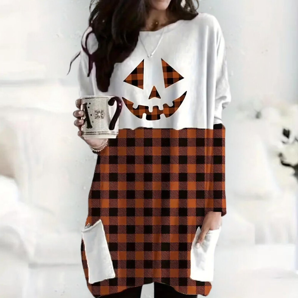 Vrouw in oversized Halloween-trui met pompoenprint en ruitpatroon, houdt mok vast. Trendy herfstmode, comfortabele kledingstijl.