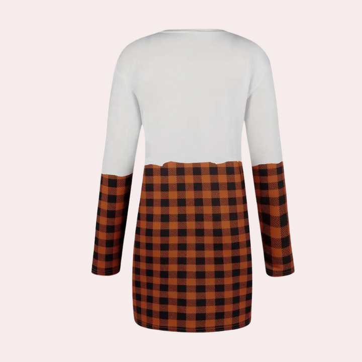 Achteraanzicht van een damesjurk met lange mouwen, wit bovenstuk en bruin-zwart geruite rok. Modieuze herfstkleding, casual stijl.