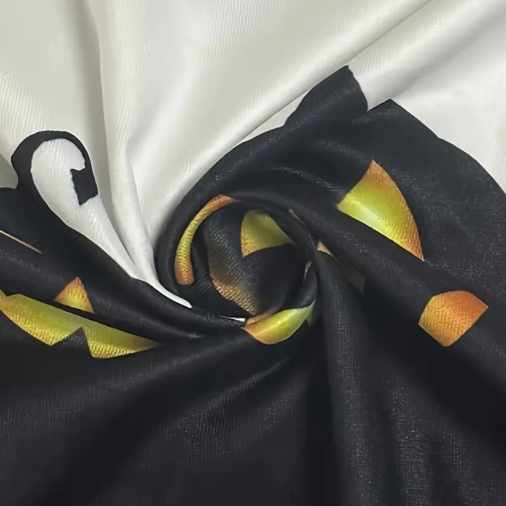 Zwarte en oranje stof met abstract patroon, gedraaid in een spiraal op witte achtergrond. Ideaal voor mode, textielontwerp en interieurdecoratie.