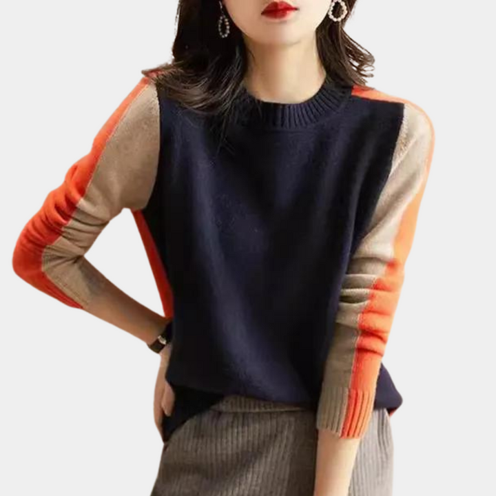 Vrouw draagt stijlvolle trui met kleurblokken in marineblauw, oranje en beige. Modieuze dameskleding, herfstmode, casual chic outfit.