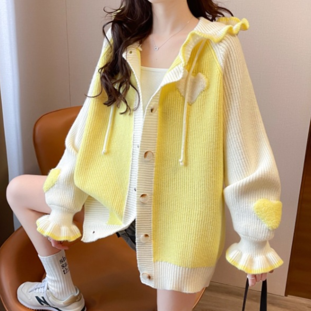 Dames gele en witte gebreide cardigan met hartjes, knopen en ruches. Trendy oversized vest, perfect voor casual lente- en herfstoutfits.