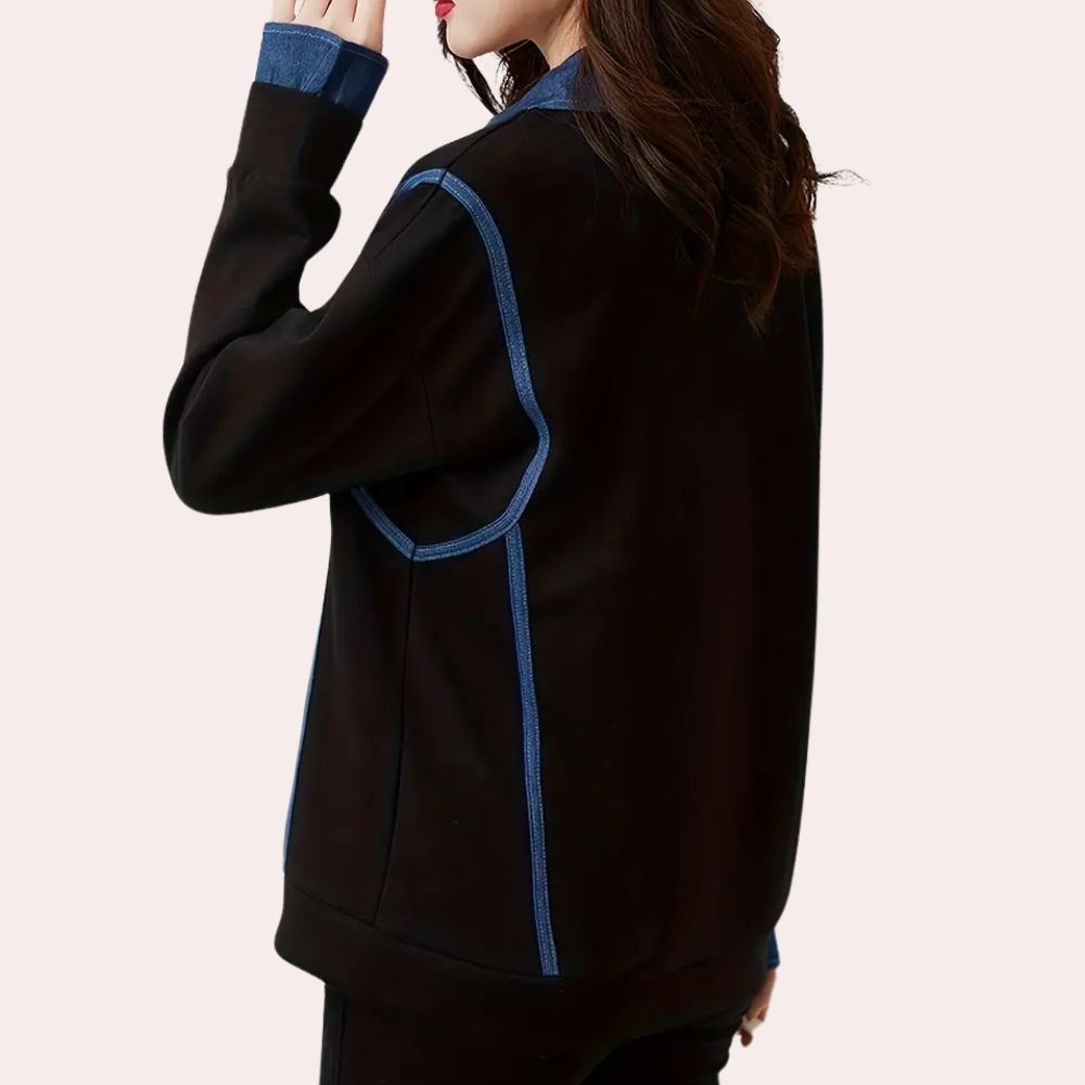 Vrouw draagt zwarte jas met blauwe accenten, denim kraag en lange mouwen. Modieuze dameskleding, casual stijl, herfst-winter mode.