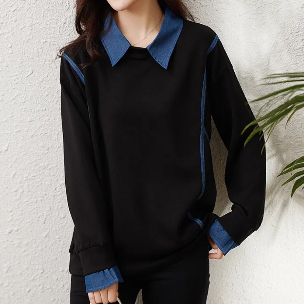 Vrouw draagt zwarte trui met blauwe kraag en manchetten, casual mode, herfstkleding, trendy dameskleding, comfortabele outfit.