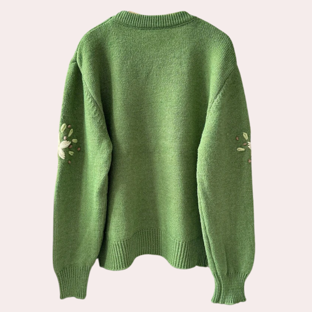 Groene gebreide trui met bloemenborduursel op de mouwen, achterkant. Comfortabele damesmode, herfstkleding, casual stijl.
