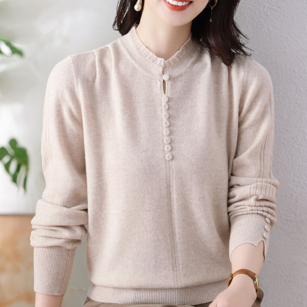 Vrouw in beige trui met knoopsluiting, lange mouwen en geribbelde boorden, tegen een neutrale achtergrond. Stijlvolle damesmode, herfstkleding.