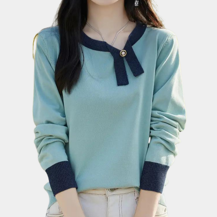 Vrouw in lichtblauwe trui met donkerblauwe boorden en strikdetail, casual mode, herfstkleding, stijlvolle damesoutfit, trendy trui.