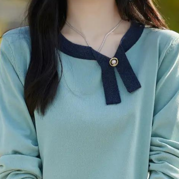 Vrouw in blauwe trui met zwarte kraag en gouden knoop, modieuze dameskleding, herfstmode, stijlvolle casual outfit, trendy damestrui.