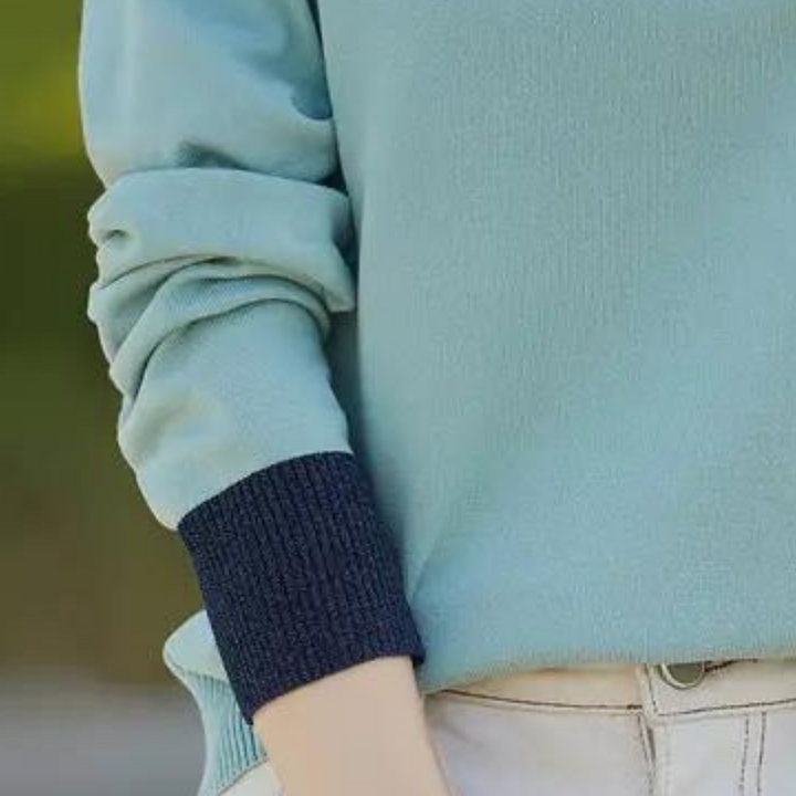 Blauwe trui met donkerblauwe boorden, casual stijl, gedragen door persoon in beige broek. Comfortabele damesmode, herfstkleding.