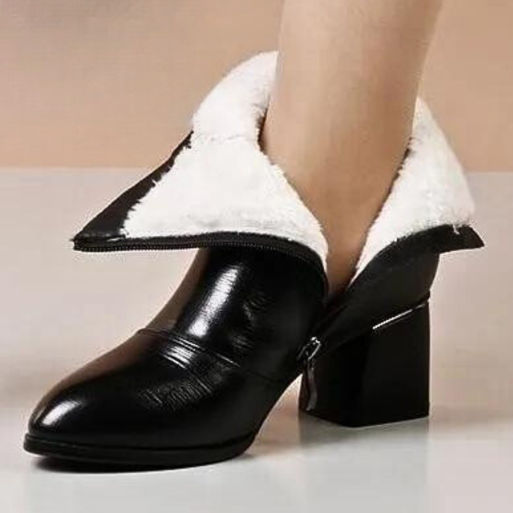 Zwarte leren enkellaars met witte bontvoering, blokhak en ritssluiting. Stijlvolle dameslaars voor wintermode en comfort.