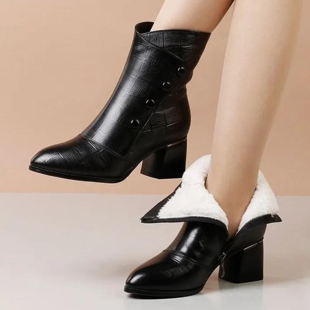 Zwarte leren dameslaarzen met hak, knopen en witte voering. Stijlvolle enkellaarzen voor herfst en winter. Modieuze schoenen voor dames.