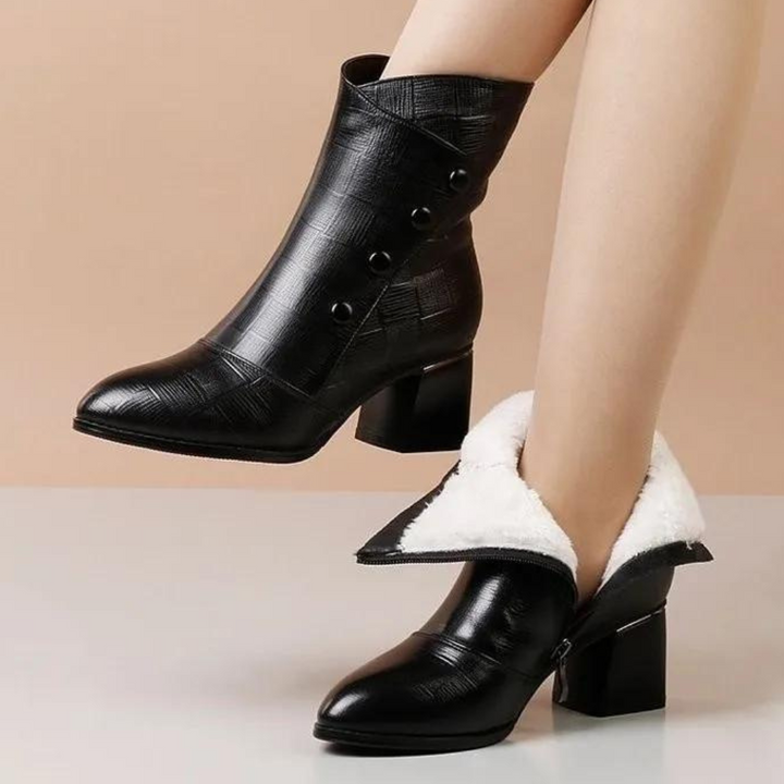 Zwarte leren dameslaarzen met hak, knopen en witte voering. Stijlvolle enkellaarzen voor herfst en winter. Modieuze schoenen voor dames.