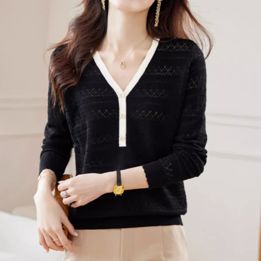 Vrouw draagt zwarte V-hals trui met witte knopen, elegante oorbellen en horloge. Modieuze dameskleding, herfstmode, stijlvolle outfit.