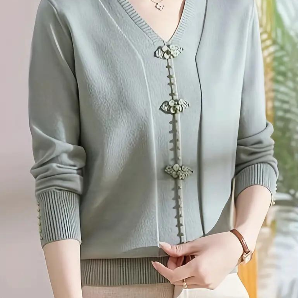 Vrouw draagt stijlvolle groene cardigan met decoratieve knopen, lange mouwen en V-hals. Modieuze dameskleding, elegant en trendy design.