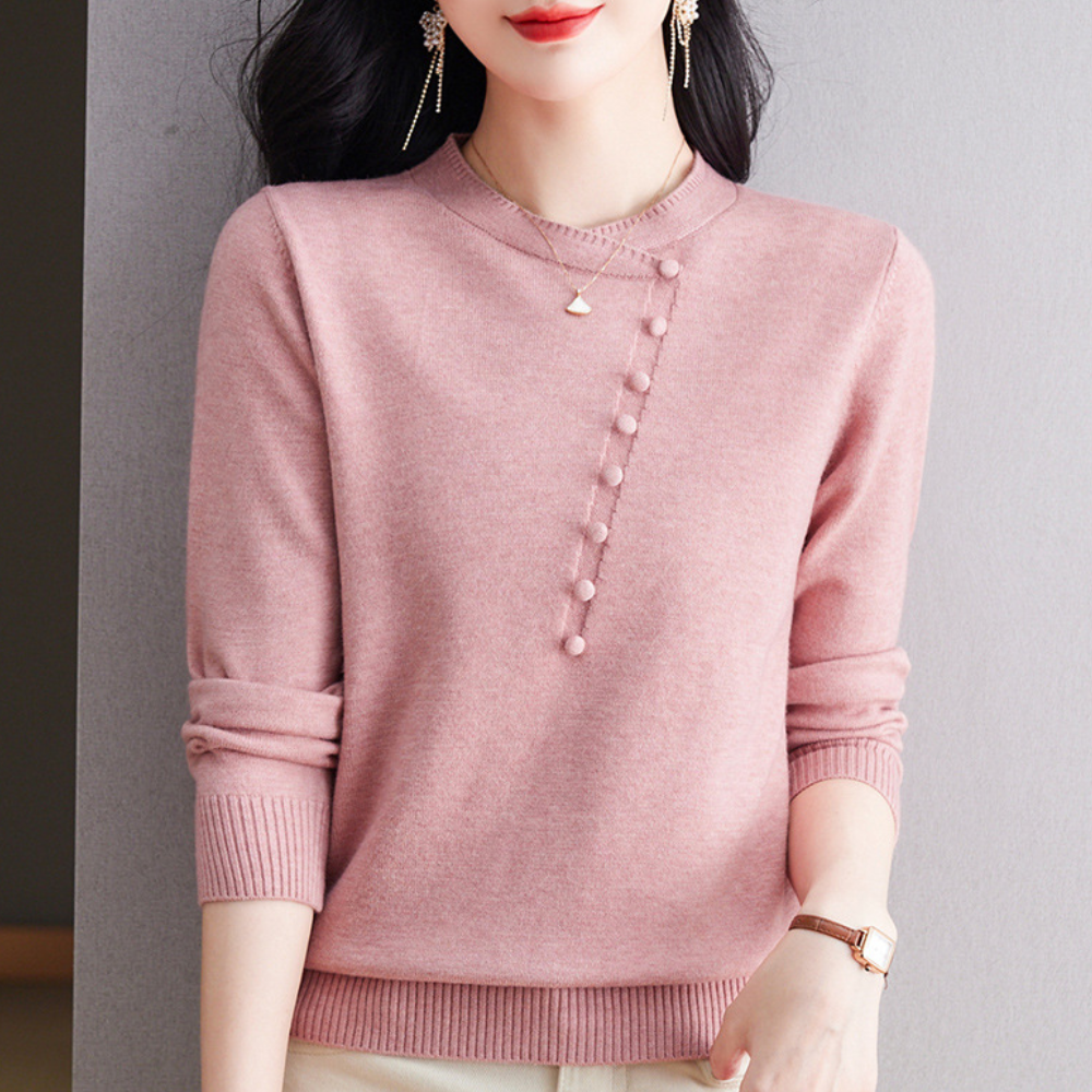 Vrouw in roze trui met knoopdetails, elegante oorbellen en horloge. Modieuze dameskleding, herfststijl, casual chic outfit.
