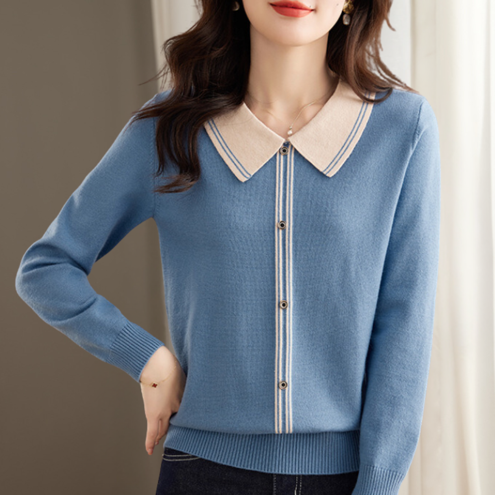 Vrouw draagt blauwe trui met beige kraag en knopen, stijlvolle damesmode, casual chique outfit, herfstkleding, elegante damestrui.