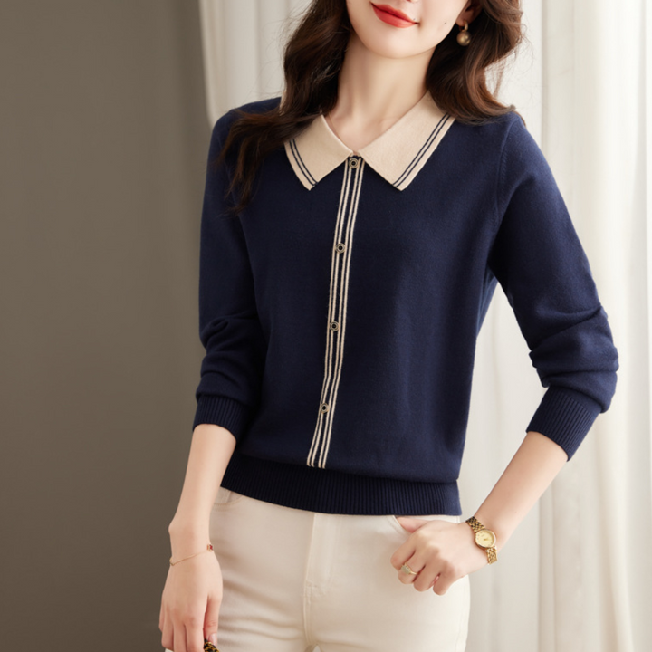 Vrouw in navy blauwe trui met contrasterende kraag en knopen, gecombineerd met witte broek. Elegante damesmode, herfstkleding, stijlvolle outfit.