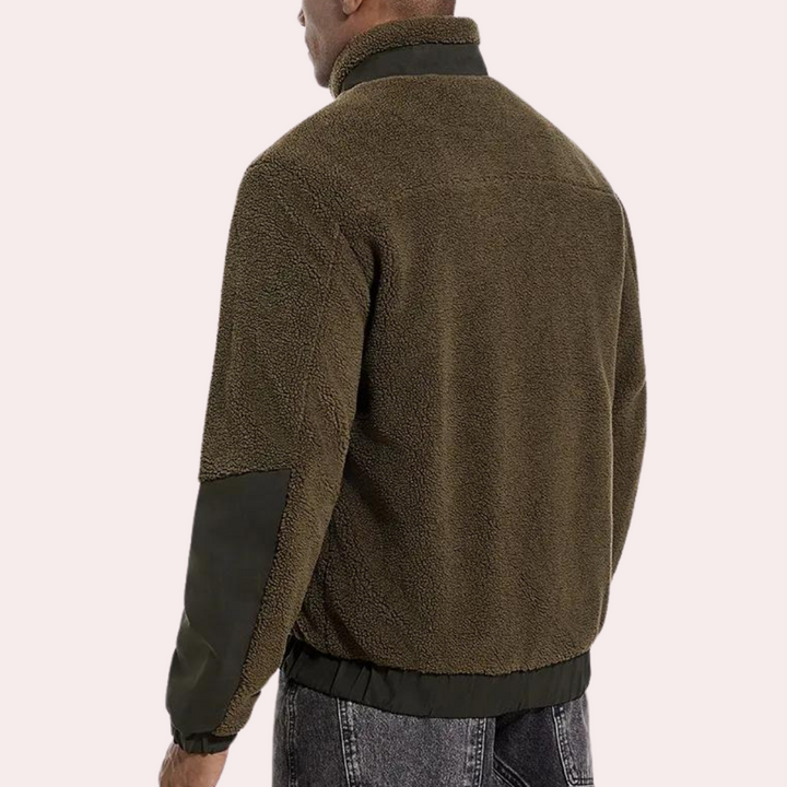 Man in bruine fleece jas met zwarte accenten, rugaanzicht. Modieuze herenkleding, warme winterjas, casual stijl, comfortabele pasvorm.