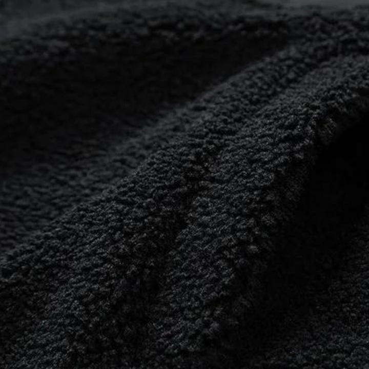 Zwarte fleece stof textuur, close-up. Zachte, pluizige stof ideaal voor warme kleding en dekens. Perfect voor wintermode en huistextiel.