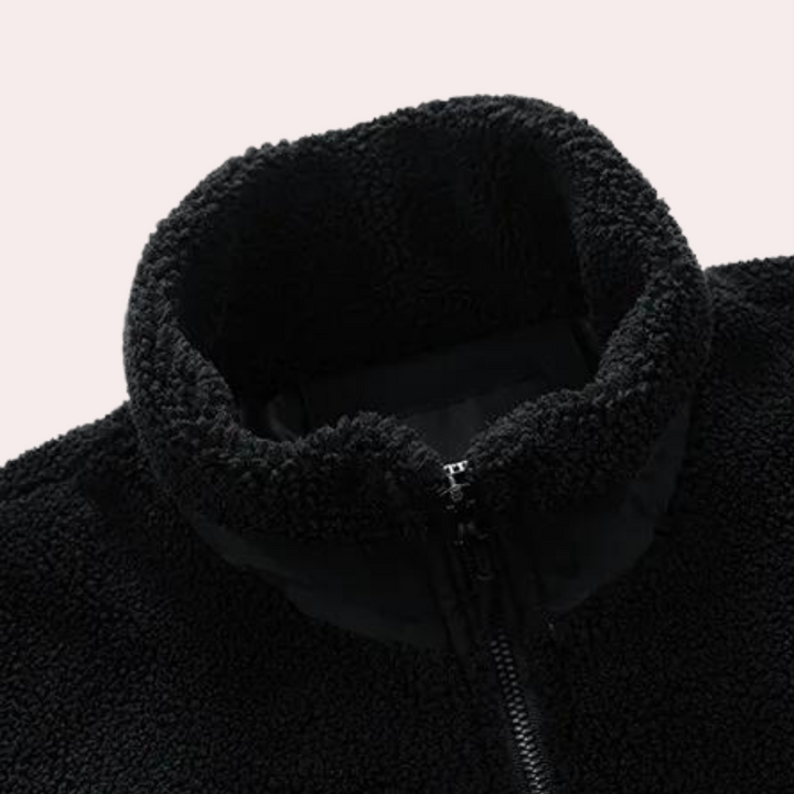 Zwarte fleece trui met hoge kraag en ritssluiting, gemaakt van zachte, pluizige stof. Ideaal voor wintermode en casual comfort.