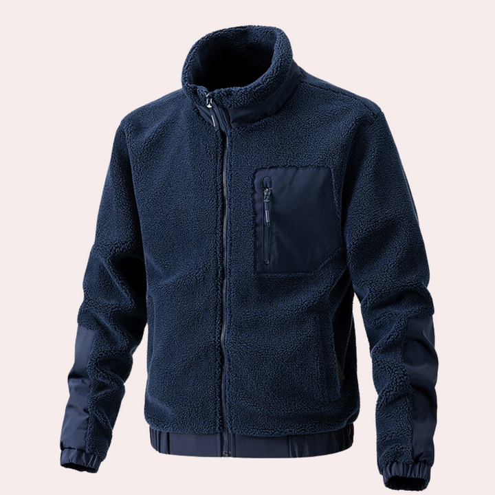 Donkerblauwe fleece jas met rits, borstzak en elastische manchetten. Warme herenjas, ideaal voor outdoor activiteiten en casual gebruik.