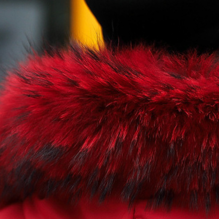 Rode bontkraag op zwarte hoed, close-up. Luxe wintermode, warme accessoires, stijlvolle dameskleding. Trendy en elegant ontwerp.