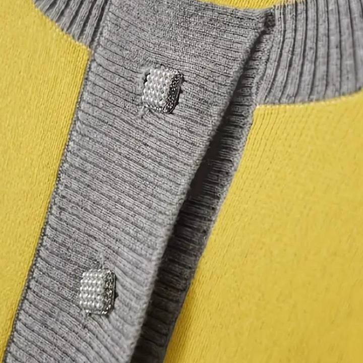 Grijze gebreide trui met gele achtergrond, detail van knopen en kraag. Modieuze dameskleding, herfstcollectie, hoogwaardige stof.