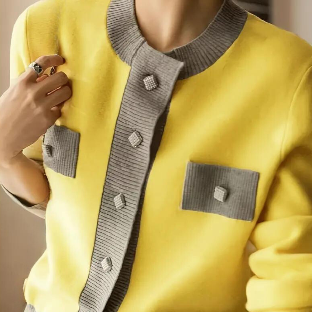 Vrouw draagt gele jas met grijze accenten en diamantvormige knopen. Modieuze dameskleding, stijlvolle herfstoutfit, trendy design.