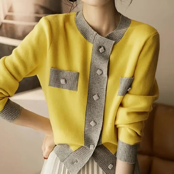 Vrouw draagt gele cardigan met grijze accenten en diamantvormige knopen, stijlvolle damesmode, herfstkleding, trendy vest, elegante outfit.