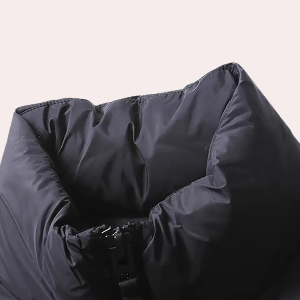 Zwarte gewatteerde jas met hoge kraag, detailopname. Modieuze winterjas, warme isolatie, unisex design, ideaal voor koude seizoenen.