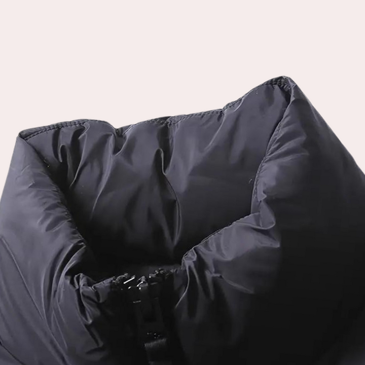 Zwarte gewatteerde jas met hoge kraag, detailopname. Modieuze winterjas, warme isolatie, unisex design, ideaal voor koude seizoenen.