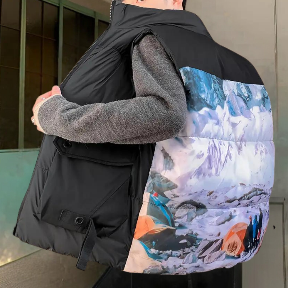 Zwarte gewatteerde bodywarmer met berglandschap print, ideaal voor outdoor avonturen. Comfortabele pasvorm, trendy design, wintermode 2023.