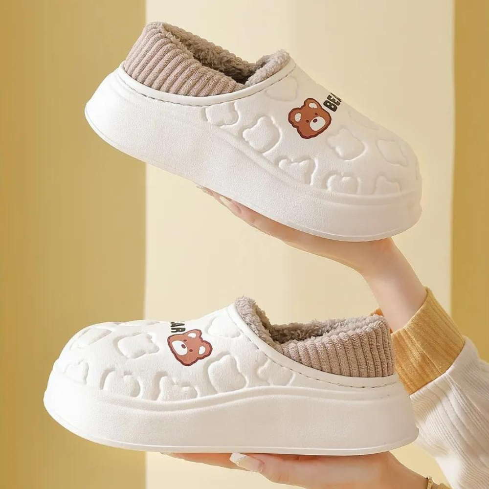Witte pluche pantoffels met berenprint, dikke zool en geribbelde voering. Comfortabele winterhuispantoffels voor dames en heren.